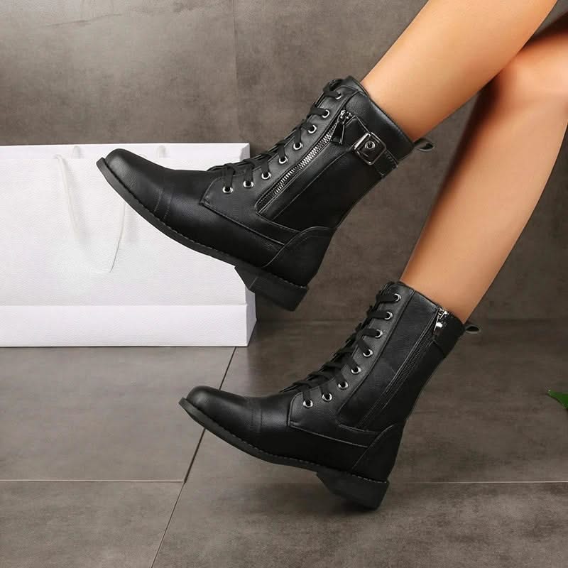 Black leather lace-up ankle boots worn with black socks.