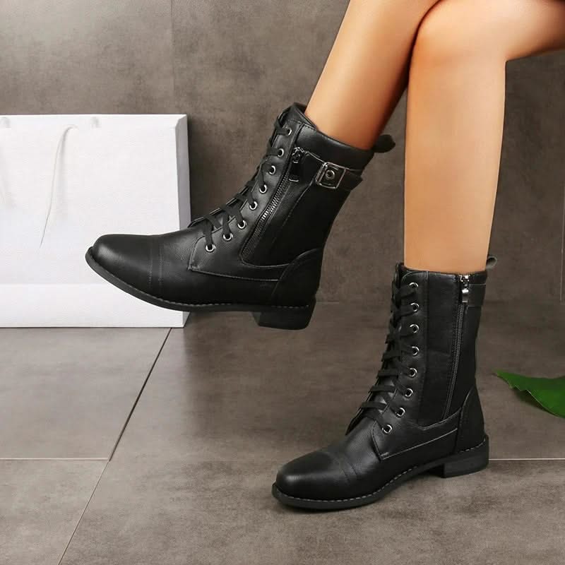 Black leather lace-up ankle boots worn with black socks.