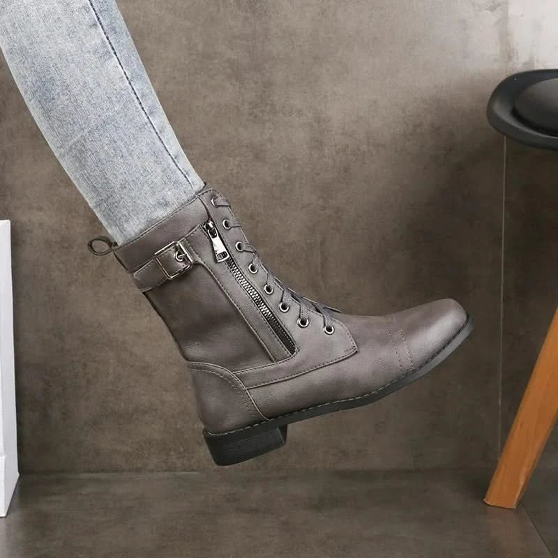 Gray leather lace-up ankle boots worn with cuffed gray jeans.