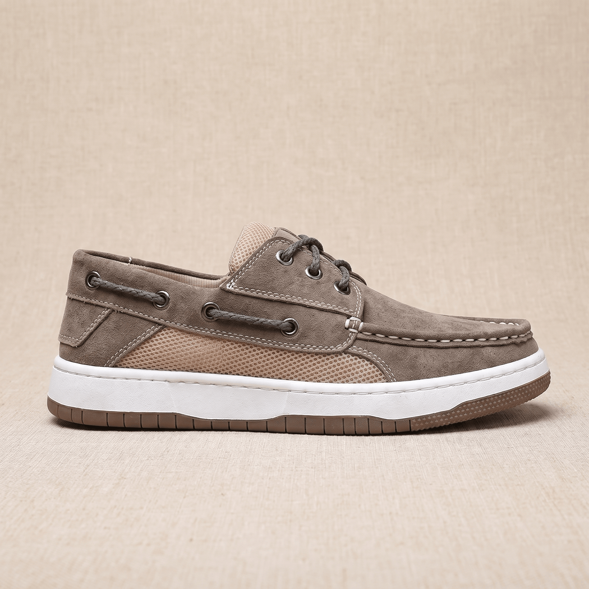 Side profile view of a single gray suede Adrian boat shoe showing the tan mesh panel and layered rubber sole