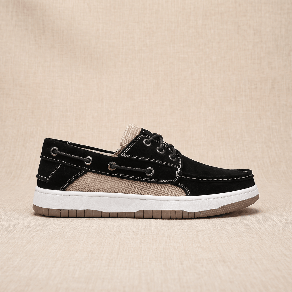Side profile view of a single black suede Adrian boat shoe showing the beige mesh panel and tan sole