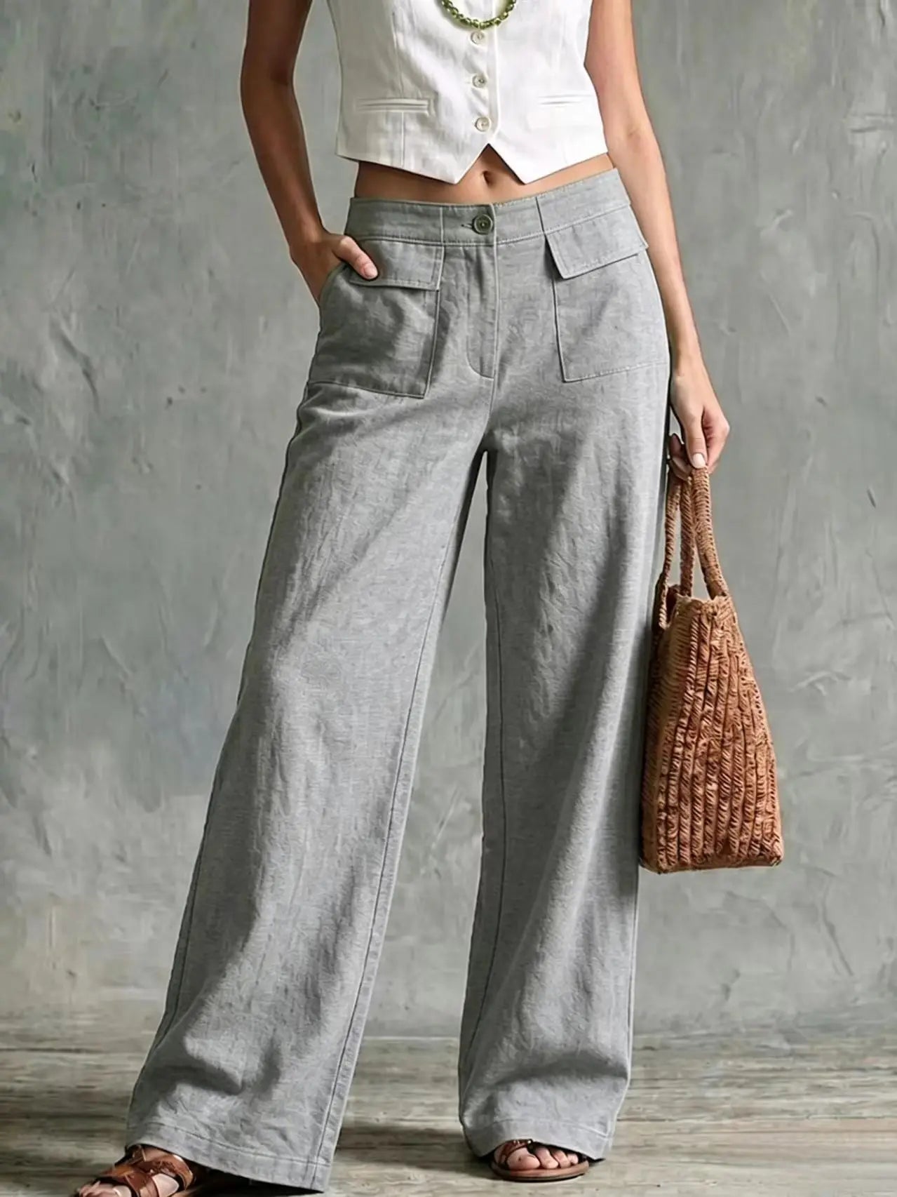Women's light gray wide-leg linen pants with a high waist, front pleats, side pockets, and a relaxed fit.