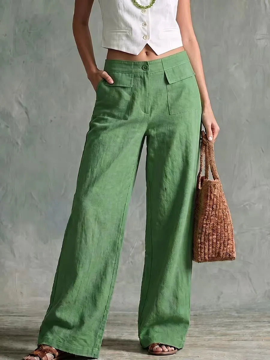 Women's green high-waisted wide-leg linen pants featuring front pleats and a relaxed, flowing silhouette.