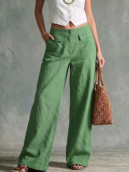 Women's green high-waisted wide-leg linen pants featuring front pleats and a relaxed, flowing silhouette.