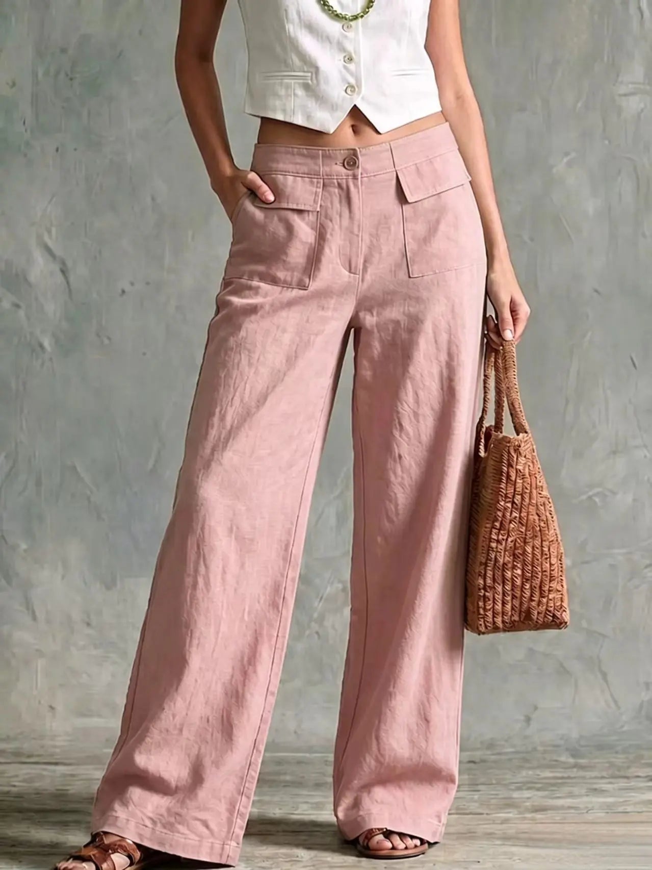 Women's pink high-waisted wide-leg linen pants with front pleats, side pockets, and a flowy fit.
