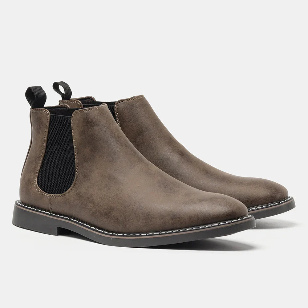 Pair of taupe leather Chelsea boots with elastic side panels and pull tabs, standing together on a plain white background.