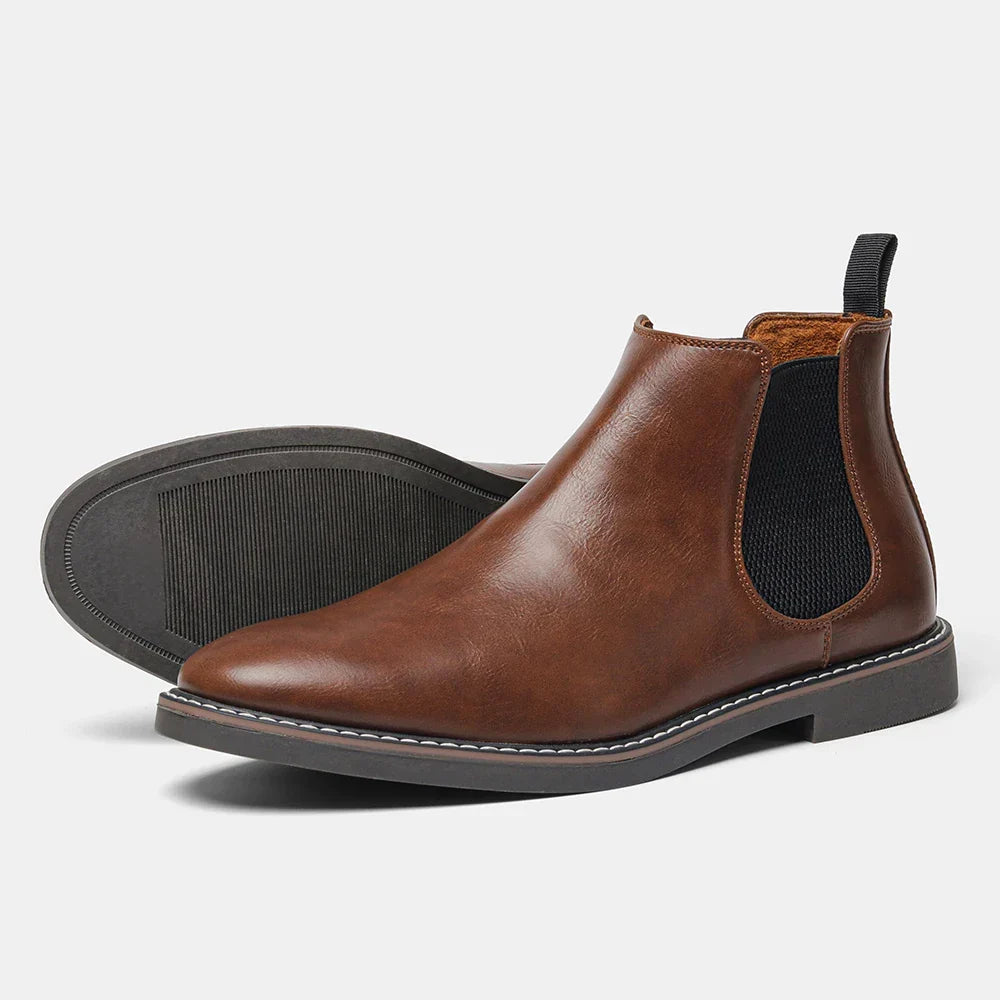 A single brown leather Chelsea boot with an elastic side panel and pull tab, shown tipped on its side on a plain white background to reveal the sole.