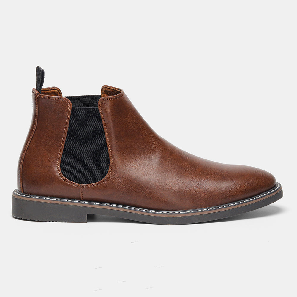 A single brown leather Chelsea boot shown in side profile on a plain white background, highlighting the elastic panel and stitched sole.