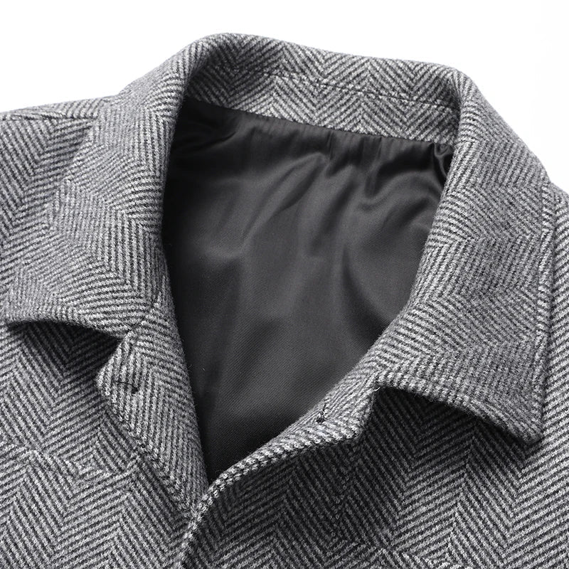 Close-up of the textured gray fabric, spread collar, and black lining of a men's wool jacket.