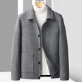 Men's gray textured wool jacket with a button-front closure, spread collar, patch pockets, and structured silhouette layered over a white turtleneck sweater.