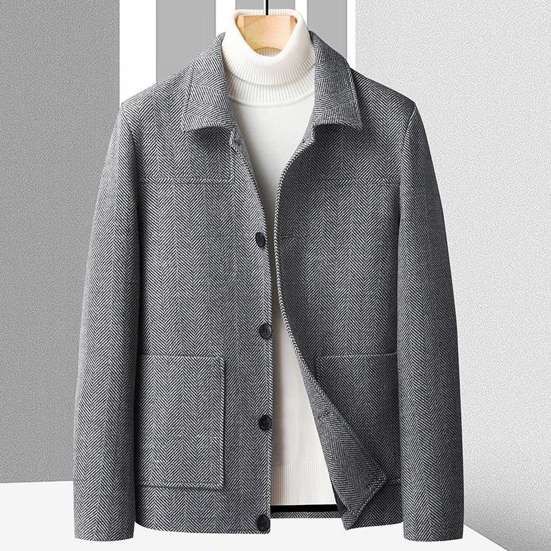 Men's gray textured wool jacket with a button-front closure, spread collar, patch pockets, and structured silhouette layered over a white turtleneck sweater.