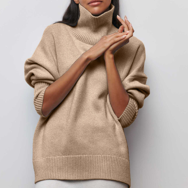 Woman wearing a beige oversized ribbed turtleneck sweater featuring short sleeves and a relaxed fit.