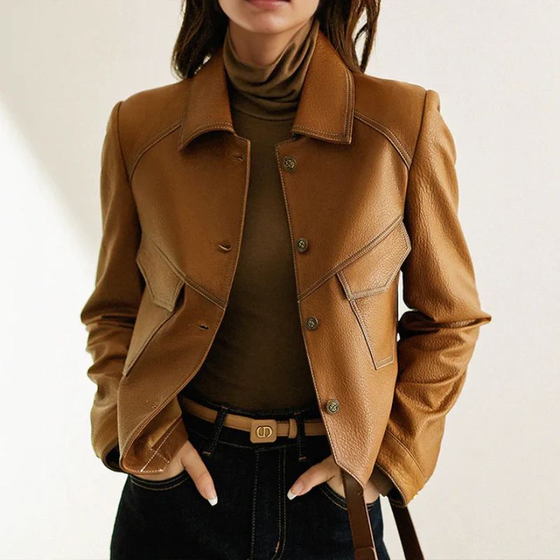 Model wearing Bettina cropped brown leather jacket buttoned closed over a turtleneck with a tonal belt