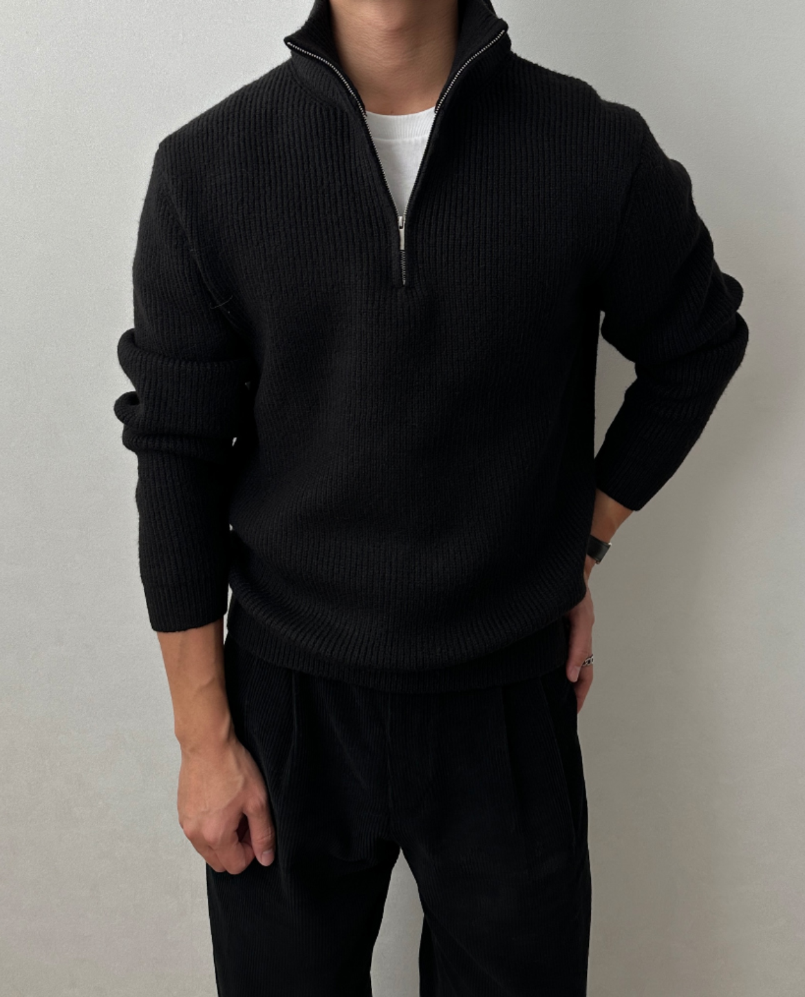 Black brushed rib-knit quarter-zip sweater with a stand collar, worn over a white tee in a regular fit.