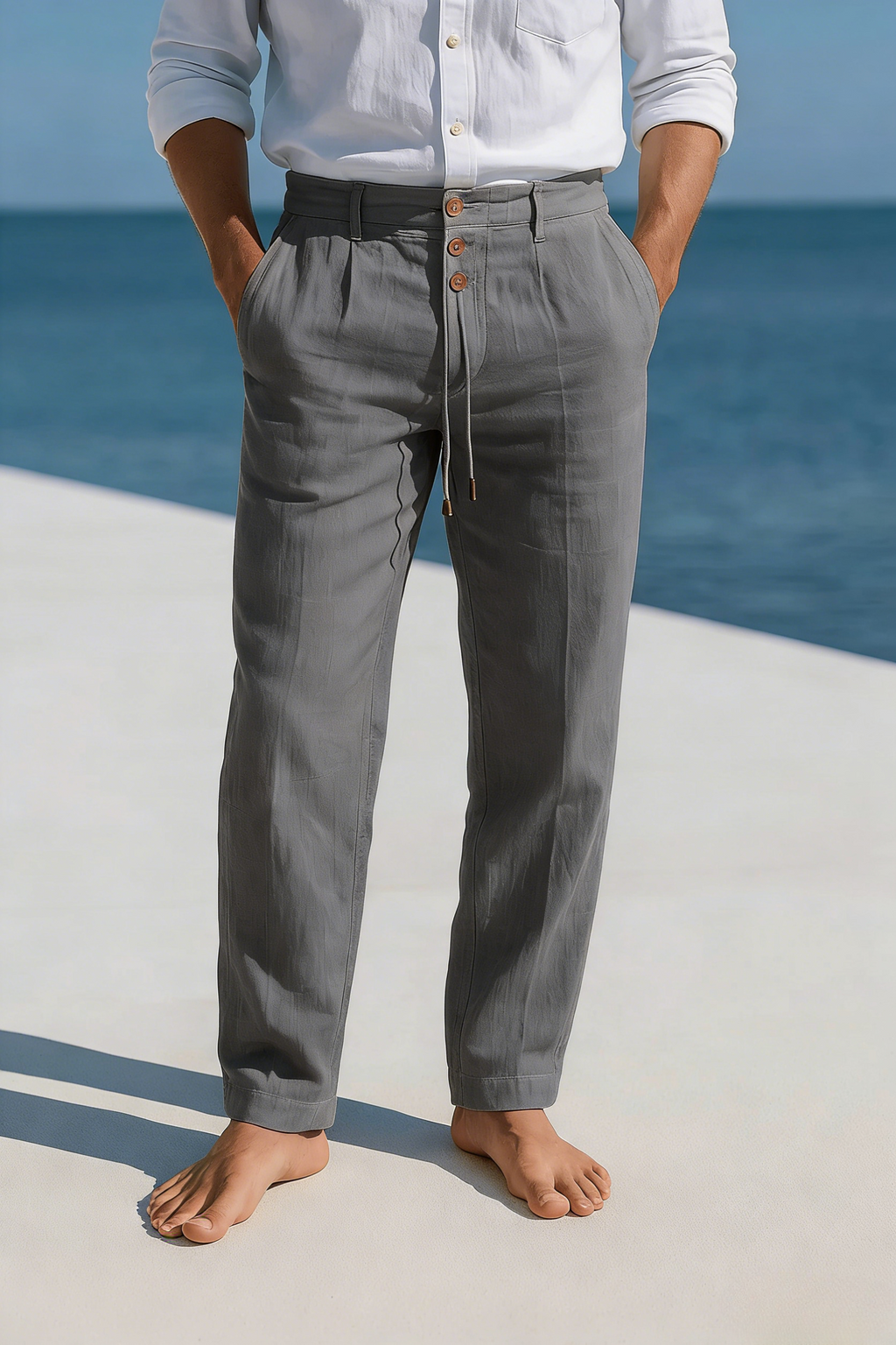 Man wearing gray linen drawstring pants with an elastic waistband, straight-leg silhouette, and lightweight construction.