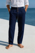 Man wearing navy linen drawstring pants with a relaxed straight-leg fit, elastic waistband, and lightweight breathable fabric.