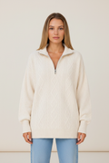 Cable knit half-zip pullover worn by a female model in cream, front view