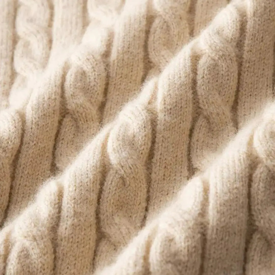 Cream-colored cable knit sweater featuring a narrow, structured texture and soft, dense yarn construction.