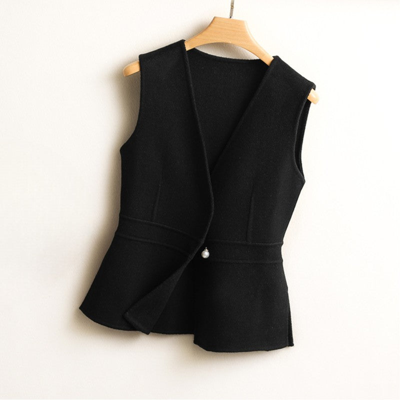 Women's black sleeveless wrap sweater vest featuring a V-neck, fitted waist, asymmetric front, and peplum hem.