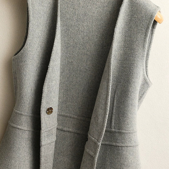 Close-up of the side seam, hem, and knit texture on a women's light gray wrap sweater vest.