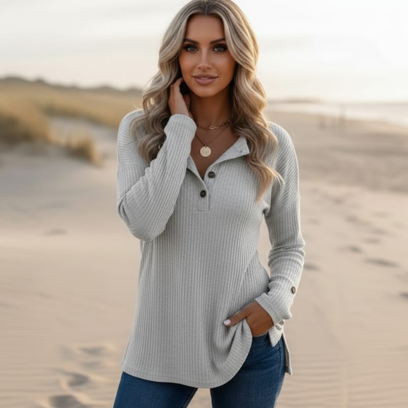 Woman wearing a light gray waffle knit Henley sweater featuring a collared button neckline, long sleeves, and a relaxed silhouette.
