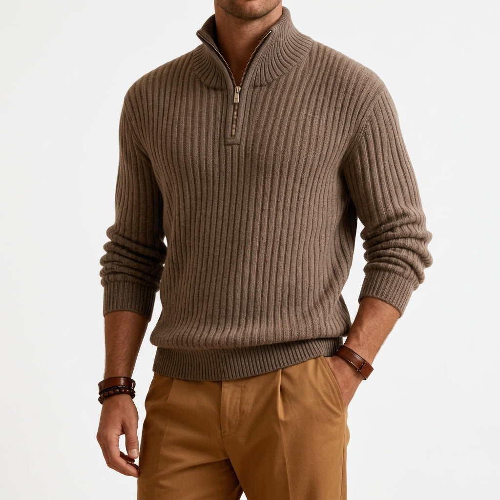 Taupe chunky ribbed quarter-zip sweater in heavyweight knit with a high stand collar and metal zipper, worn with tan chinos.