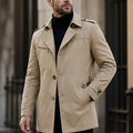Beige cotton-blend trench coat featuring a notched lapel, button front, shoulder epaulettes, and a zip chest pocket.
