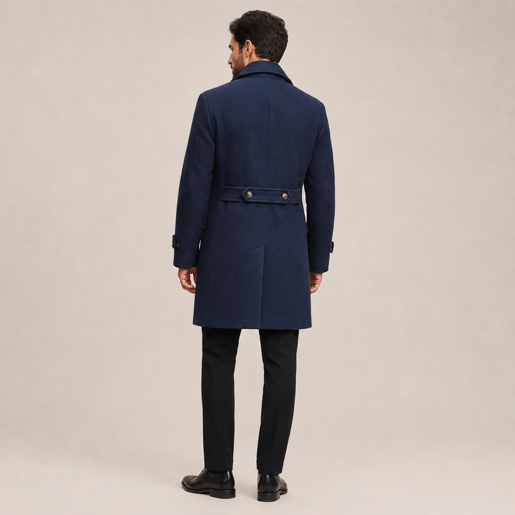 Navy blue wool-blend overcoat with a structured officer-inspired back, buttoned waist tab, and tailored fit.