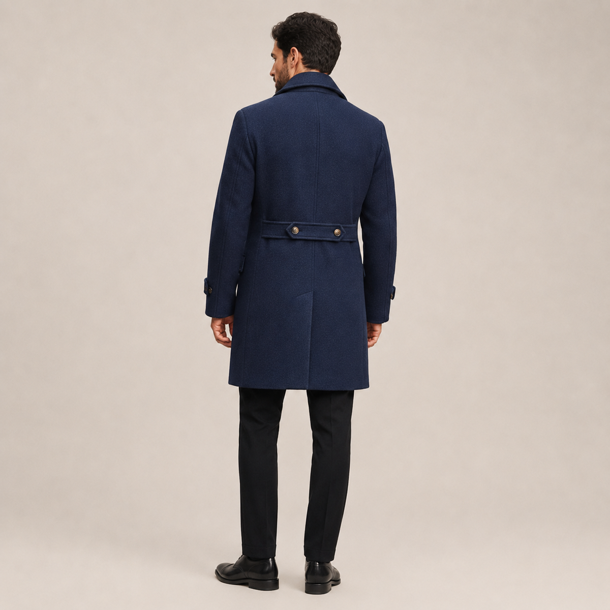 Navy blue wool-blend overcoat with a structured officer-inspired back, buttoned waist tab, and tailored fit.