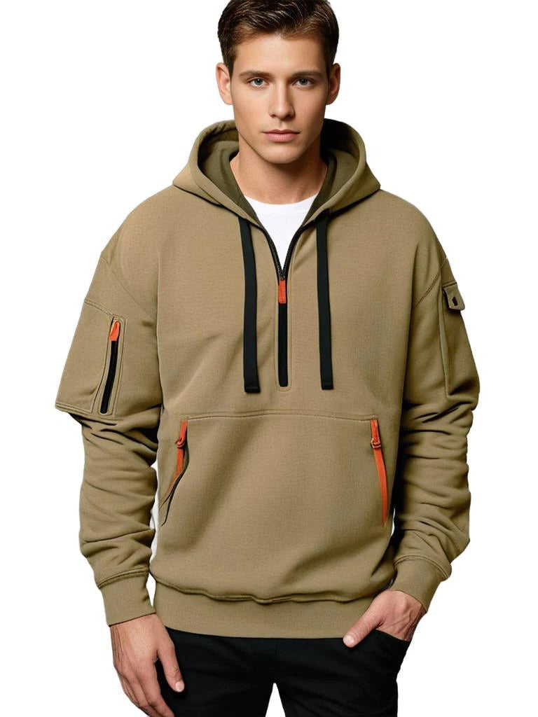 Man wearing a khaki tactical hoodie with an adjustable hood, half-zip neckline, and utility sleeve pocket.