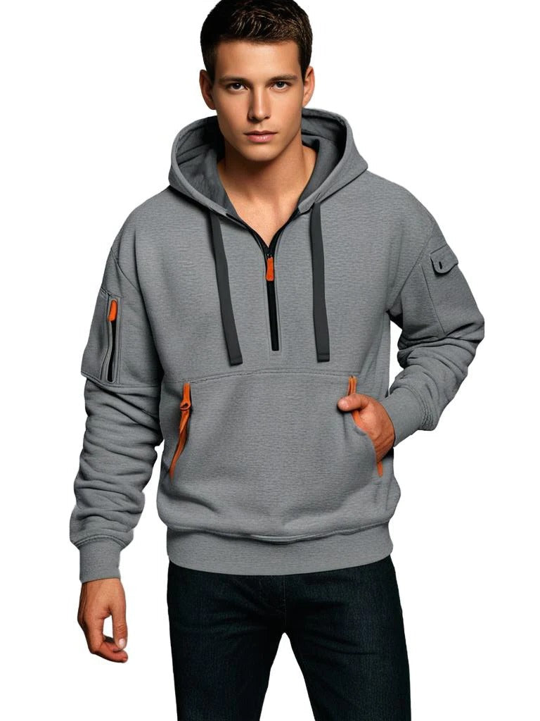 Man wearing a gray tactical hoodie with an adjustable hood, half-zip front, and utility sleeve zip pocket.