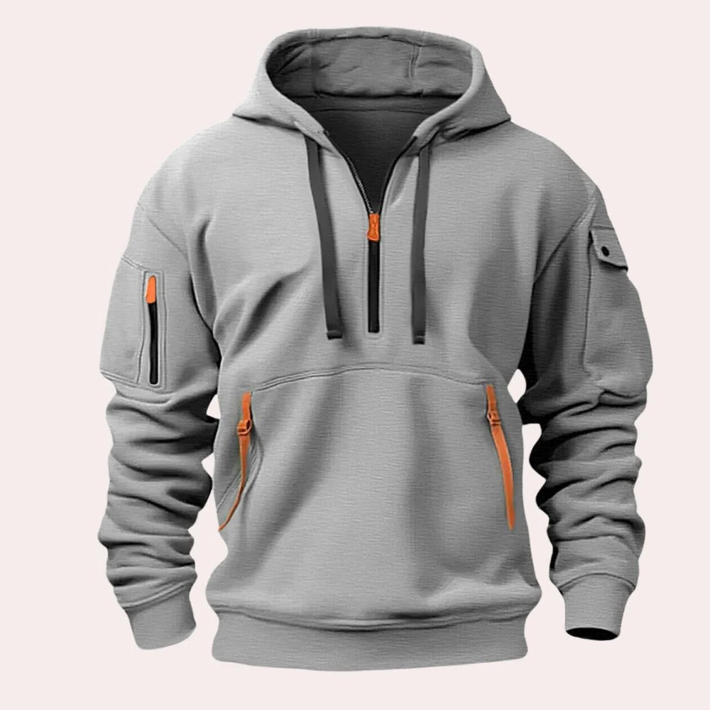 Gray tactical pullover hoodie featuring an adjustable hood, half-zip neckline, kangaroo pocket, and sleeve zip pocket on a white background.