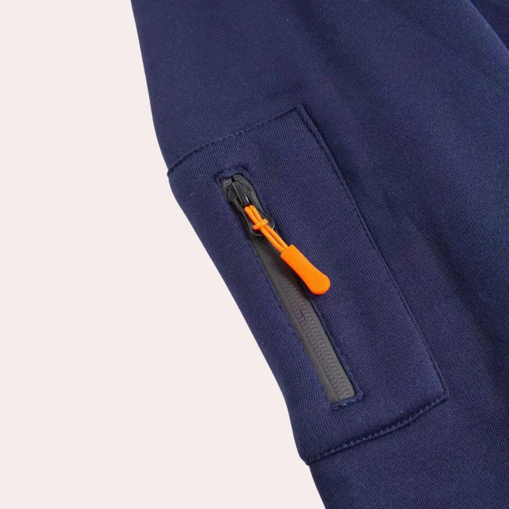 Close-up of the tactical hoodie sleeve zip pocket with orange zipper pull and durable utility fabric.