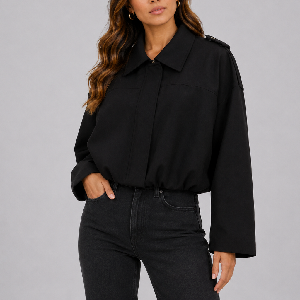 A woman wearing a cropped black suede bomber jacket with an oversized fit and wide sleeves