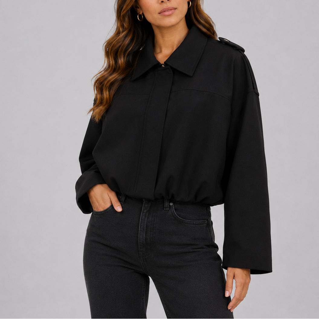 A woman wearing a cropped black suede bomber jacket with an oversized fit and wide sleeves