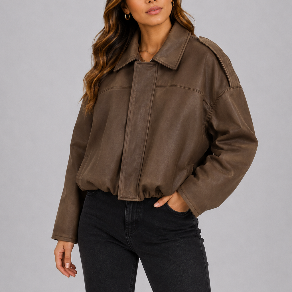 A woman wearing a cropped brown suede bomber jacket with an oversized fit and wide sleeves