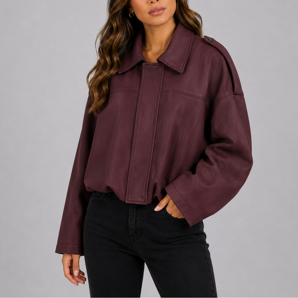 A woman wearing a cropped burgundy suede bomber jacket with an oversized fit and wide sleeves