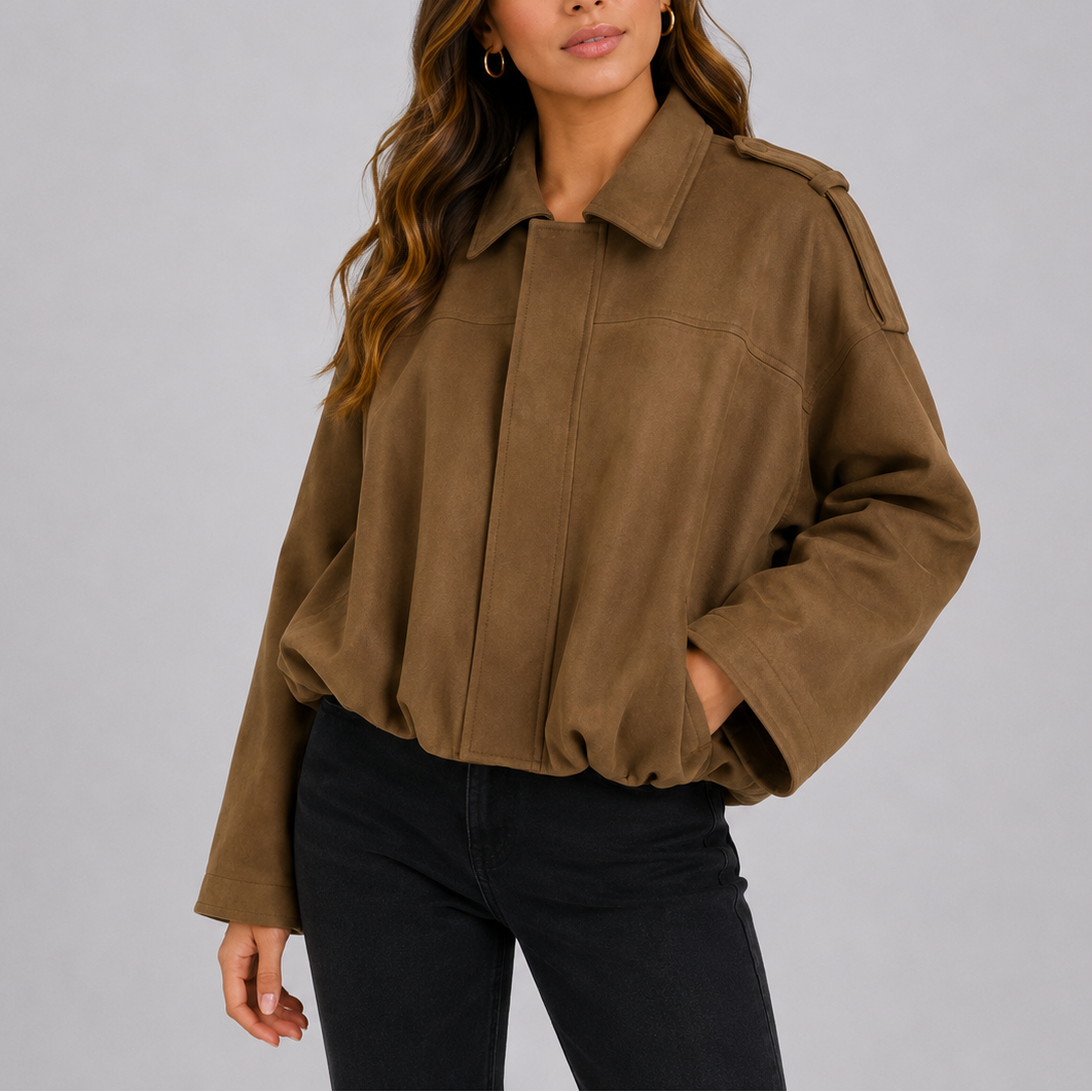 A woman wearing a cropped dark brown suede bomber jacket with an oversized fit and wide sleeves