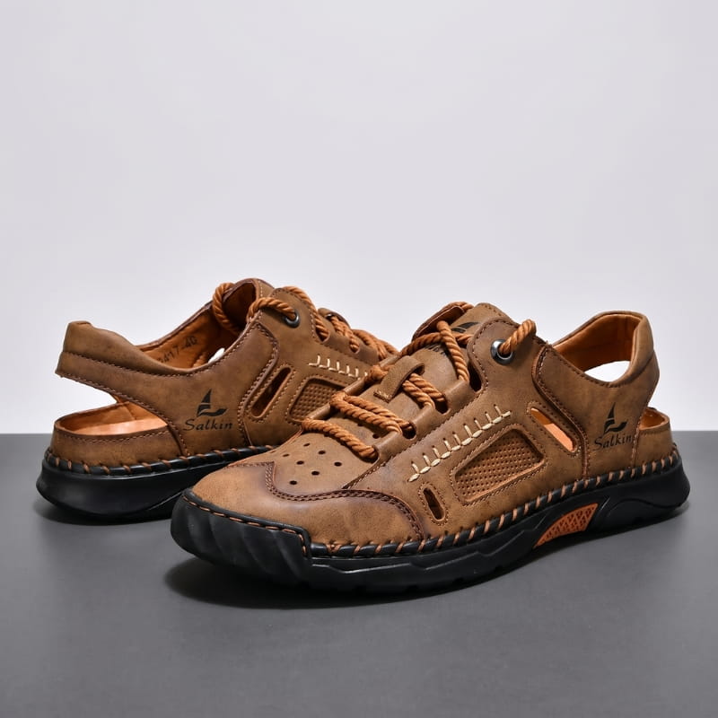 Pair of brown nubuck leather fisherman sandals stacked on a gray studio backdrop