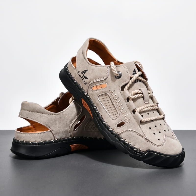 Pair of khaki nubuck leather fisherman sandals stacked on a gray studio backdrop