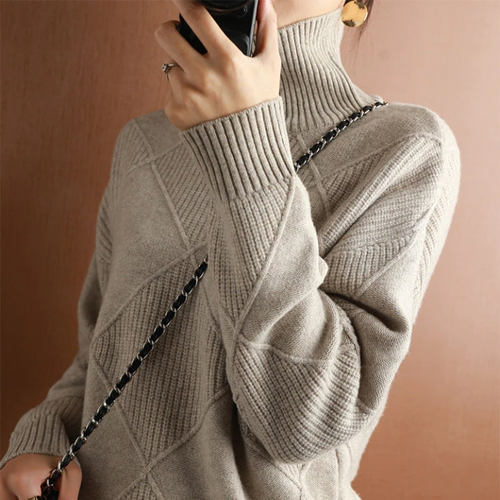 Woman wearing a light gray ribbed turtleneck knit sweater with long sleeves and a soft textured finish.