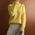 Woman wearing a mustard yellow ribbed turtleneck sweater paired with white trousers in a casual outfit.