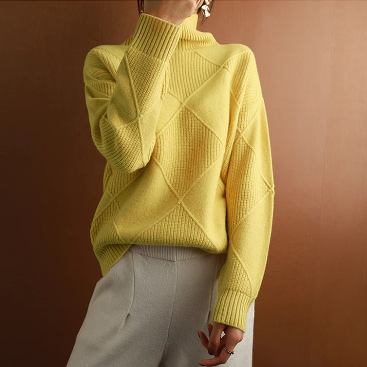 Woman wearing a mustard yellow ribbed turtleneck sweater paired with white trousers in a casual outfit.