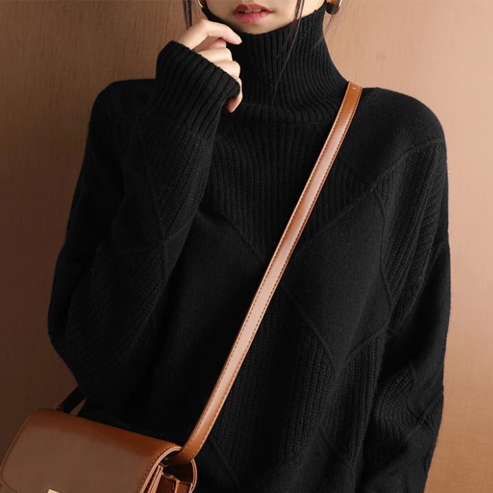 Woman wearing a black ribbed turtleneck knit sweater with a relaxed fit and crossbody bag.