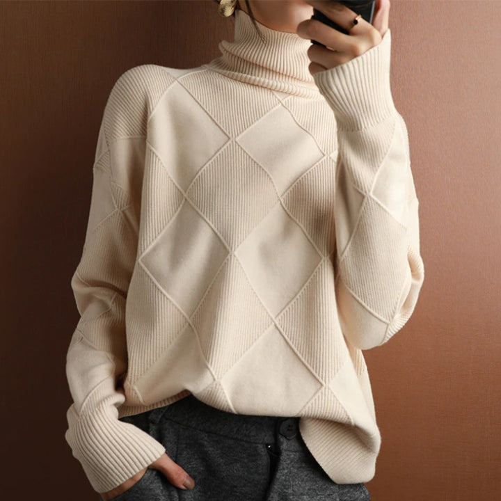 Woman wearing a cream textured turtleneck sweater with long sleeves and a relaxed silhouette.
