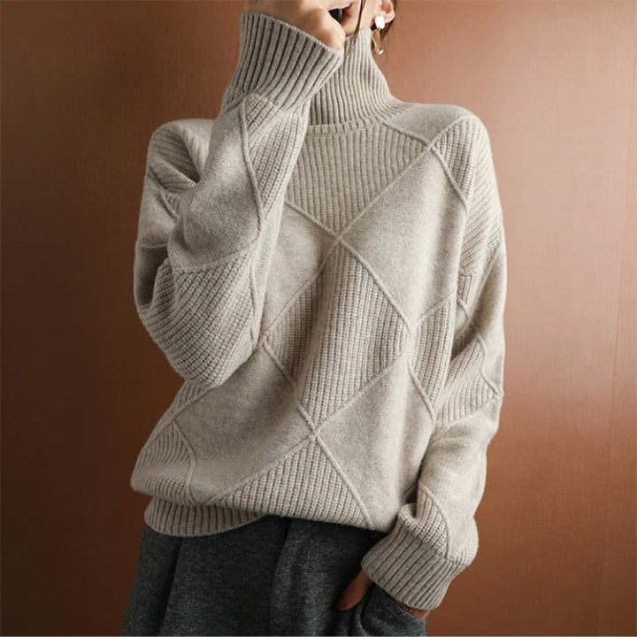 Woman wearing a light gray ribbed turtleneck knit sweater with long sleeves and a cozy relaxed fit.