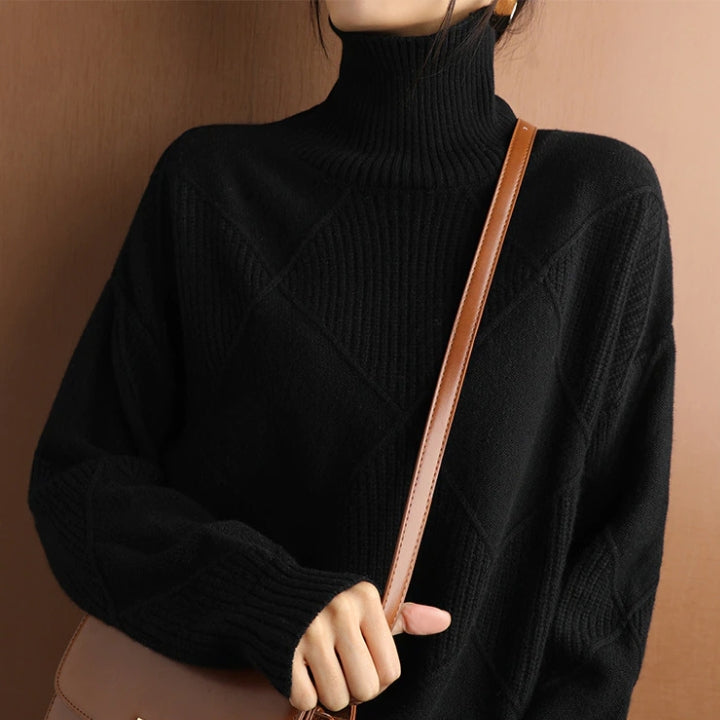 Woman wearing a black textured turtleneck sweater featuring long sleeves, ribbed cuffs, and a relaxed silhouette.