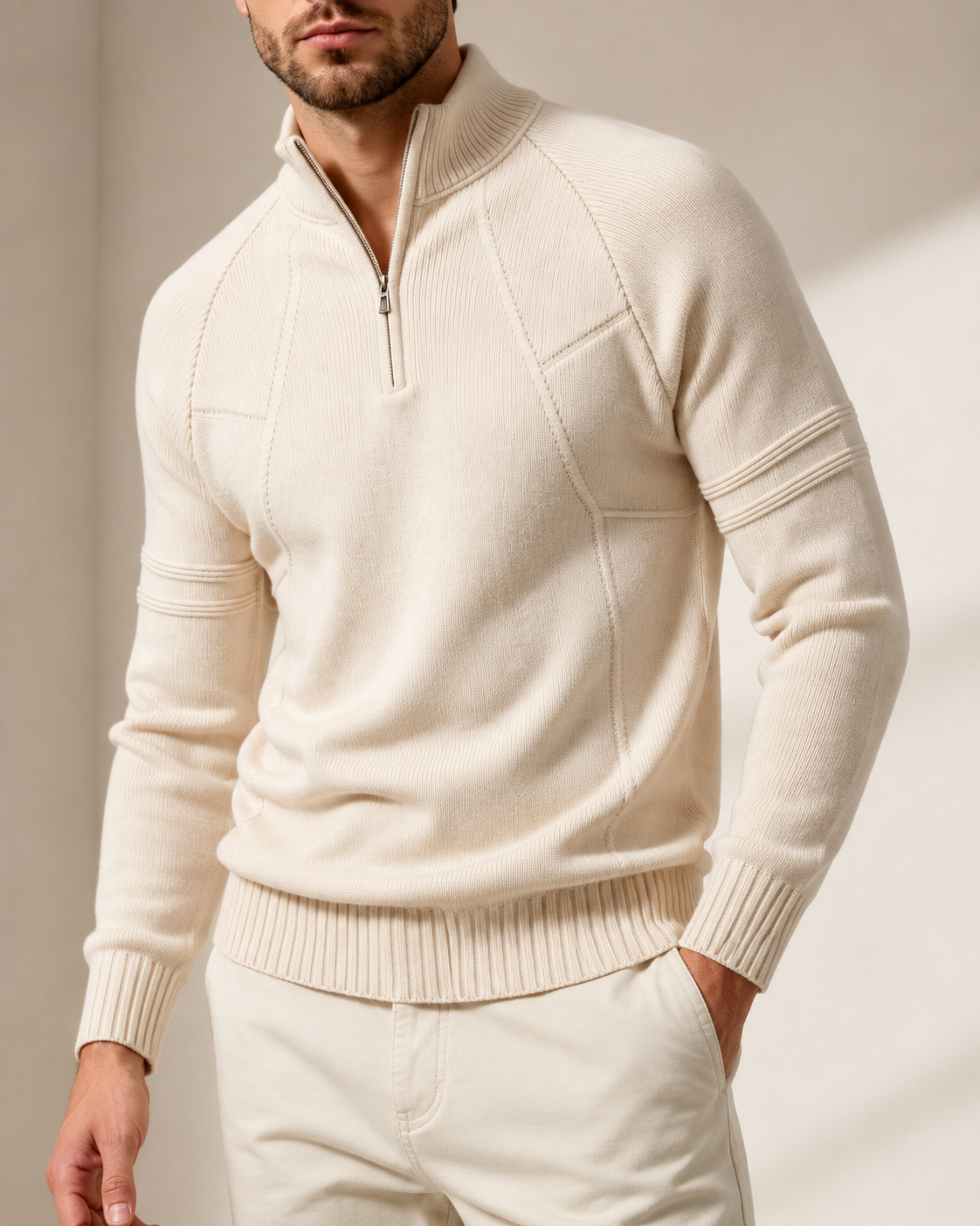 Cream fitted knit quarter-zip sweater featuring raglan sleeves, raised chest seams, and ribbed cuffs.