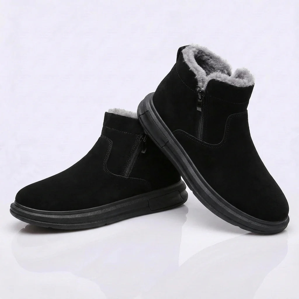 Black fur-lined winter boots worn by a person, featuring a wide toe box, side zip, and cushioned sole