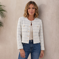 Woman wearing a light gray textured tweed jacket with gold-tone buttons, round neckline, long sleeves, and tailored silhouette with blue jeans.